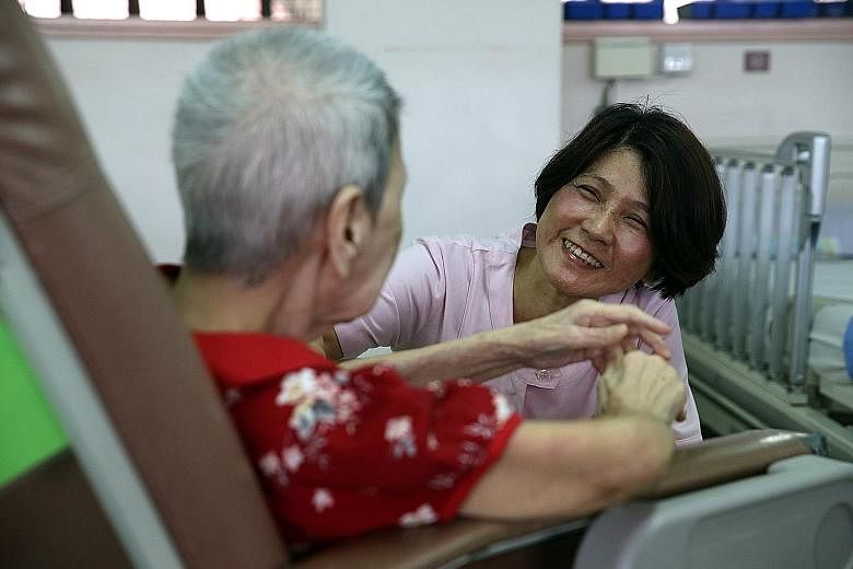 Staff nurse Lily Goh, 55, a former hospital nurse, talking to an elderly patient at Tai Pei Social Service. She left nursing for 15 years before making a comeback.