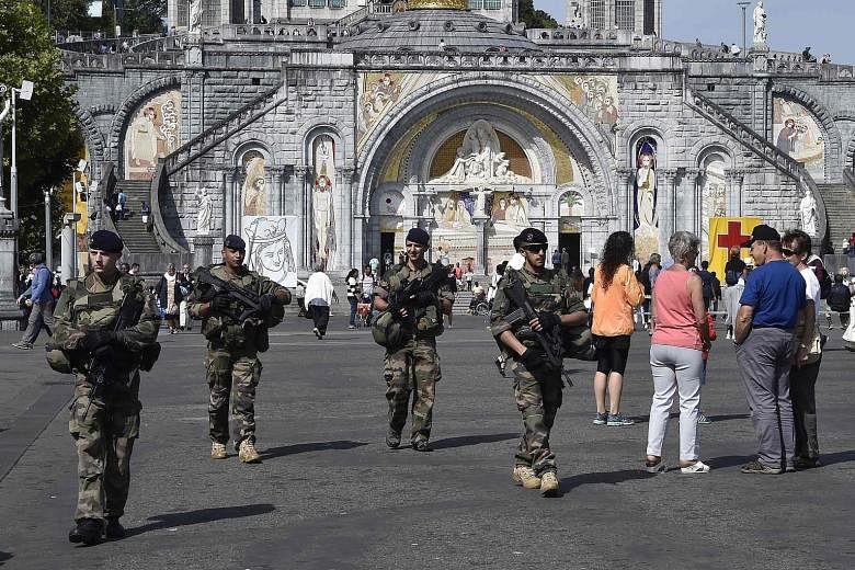 French soldiers patrolling inside the sanctuary of Lourdes as part of the Sentinelle military force security mission while people gathered for the annual Catholic pilgrimage in France yesterday.