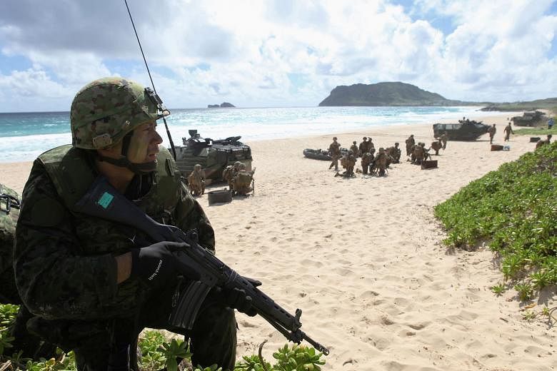 A soldier with the Japan Maritime Self-Defence Force training alongside US Marines in Hawaii last month. Japan's ruling Liberal Democratic Party and its junior coalition partner Komeito hold a two-thirds majority in Japan's Diet, and could initiate a refe