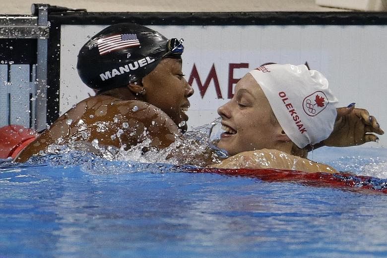 American Simone Manuel and Canadian Penny Oleksiak celebrating after both clocked 52.70sec for joint first place in the 100m freestyle - the first time this has happened in the glamour event since 1984.