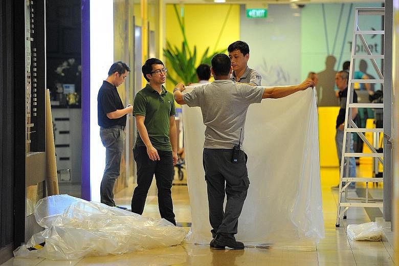 Workers clearing up the area that was cordoned off after a 20-year-old man, who is understood to have had multiple injuries, was found in a semi-conscious state and taken to Khoo Teck Puat Hospital.