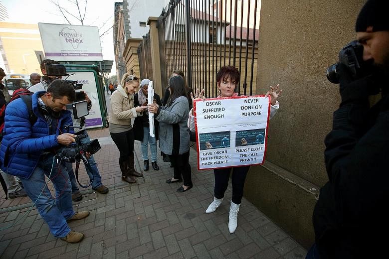 Supporters of Paralympics track star Oscar Pistorius awaiting his arrival for his sentencing at the North Gauteng High Court in Pretoria, South Africa, on July 6. His case was one of several high-profile trials that became fodder for media outlets th