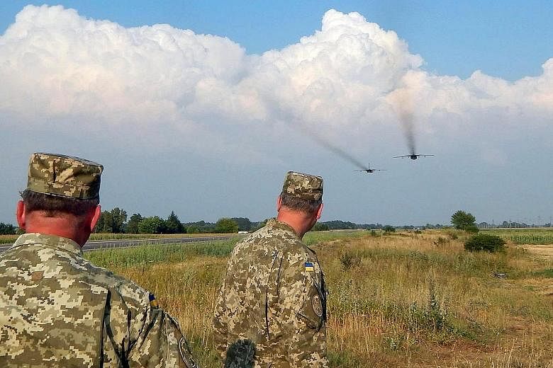 Ukrainian soldiers watching Sukhoi Su-24 front-line bombers during military aviation drills in the Rivne region in Ukraine on Wednesday.