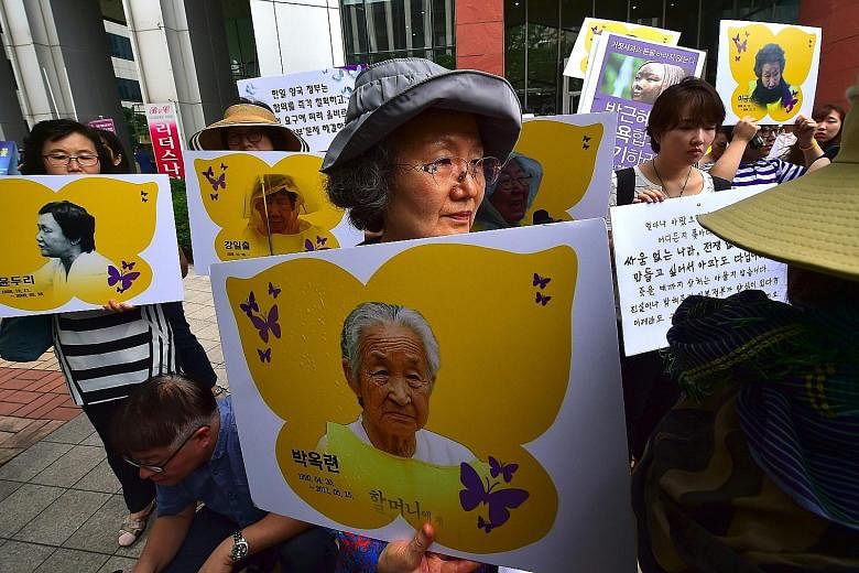 South Korean activists holding portraits of former comfort women during a rally in Seoul last month against the Reconciliation and Healing Foundation, which was set up to support comfort women. The landmark deal between South Korea and Japan to settl