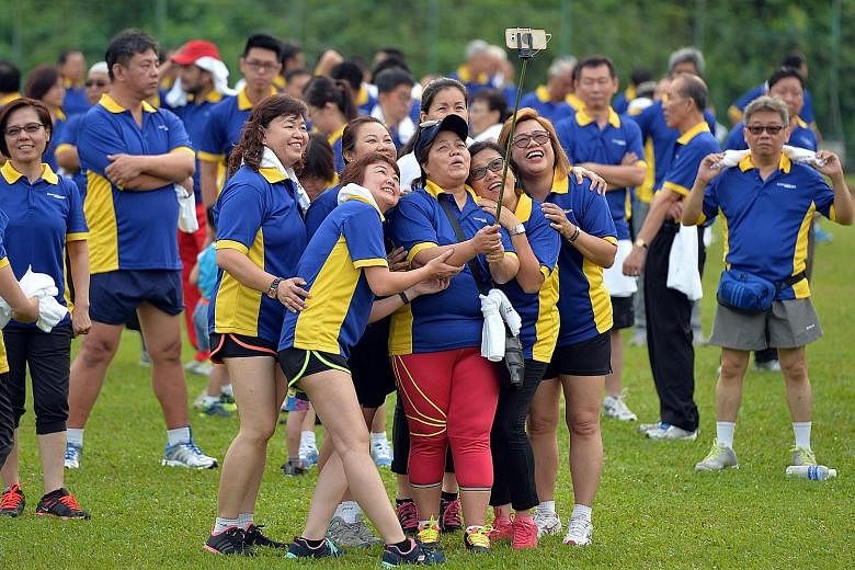 ConfortDelGro's women cabbies snapping a wefie before the morning workout yesterday. About 1,000 of the company's 37,000 taxi drivers got together with their families to exercise at Bukit Gombak Stadium.