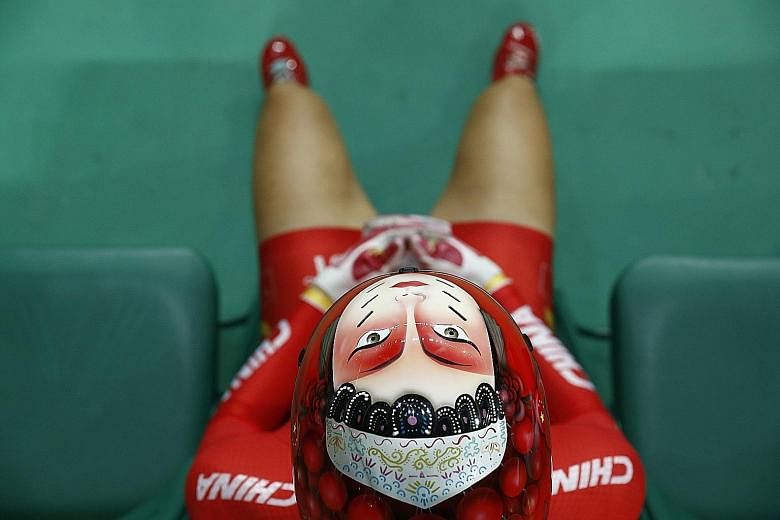 Winning shot: A face is painted onto the helmet of China's Zhong Tianshi, as she waits to compete in the women's keirin track cycling second round at the Velodrome on Saturday. She went on to finish 11th in the event won by the Netherlands' Elis Ligtlee.