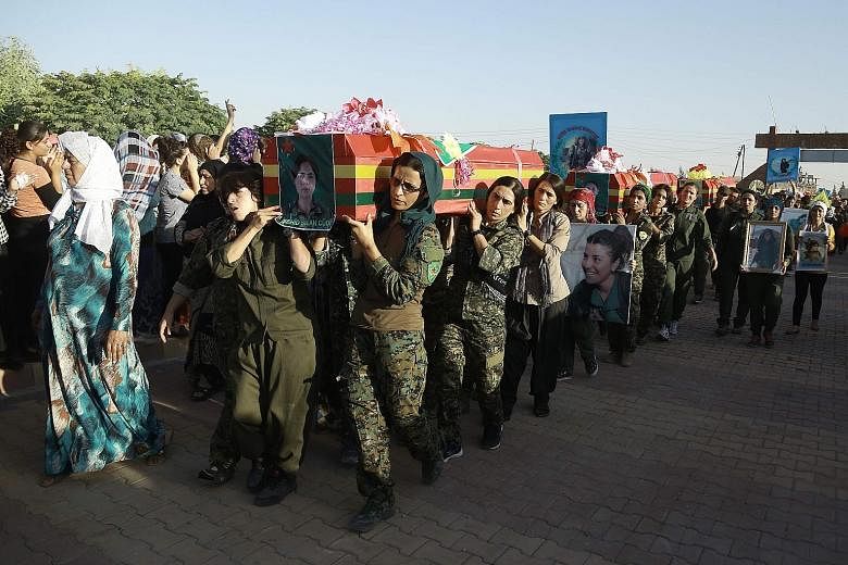 Civilians after being evacuated by Syrian Democratic Forces fighters from the previously ISIS-controlled city of Manbij, Syria. Syrian-Kurdish fighters in the Syrian city of Qamishli on Saturday carrying the coffins of comrades who were killed during