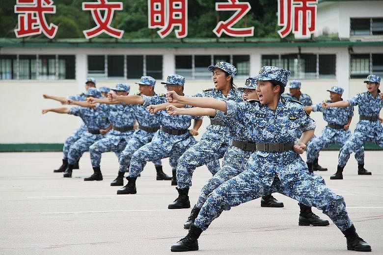 Students from Hong Kong showing off their fighting mettle yesterday at an annual summer camp organised by the Chinese People's Liberation Army. Around 120 students from colleges and universities based in Hong Kong started intensive training at the mi
