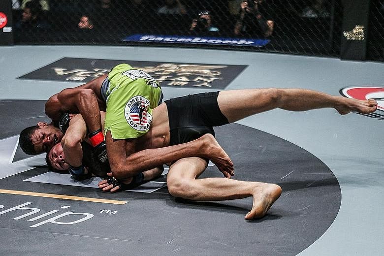 Adriano Moraes of Brazil pinning down Kyrgyzstan's Tilek Batyrov before defeating him to take the interim One flyweight world championship title in Macau last Saturday.