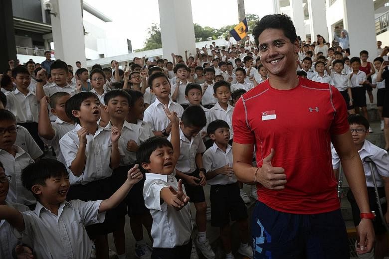 Schooling meeting his young fans at Anglo-Chinese School (Junior) yesterday. He arrived just before 8am to screams and cheers from the pupils, including those from other schools in the ACS family. Speaking to them at the auditorium, he said: "It's gr