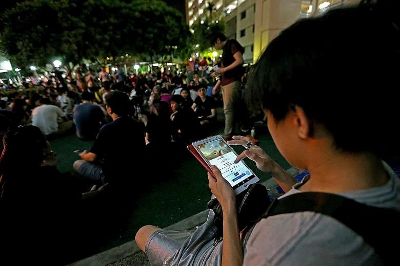 Pokemon Go players in Hougang Avenue 10, where scores of people have been seen jaywalking or running across the road while playing the mobile game. The two men arrested for affray yesterday face a prison sentence of up to one year or a fine of $5,000