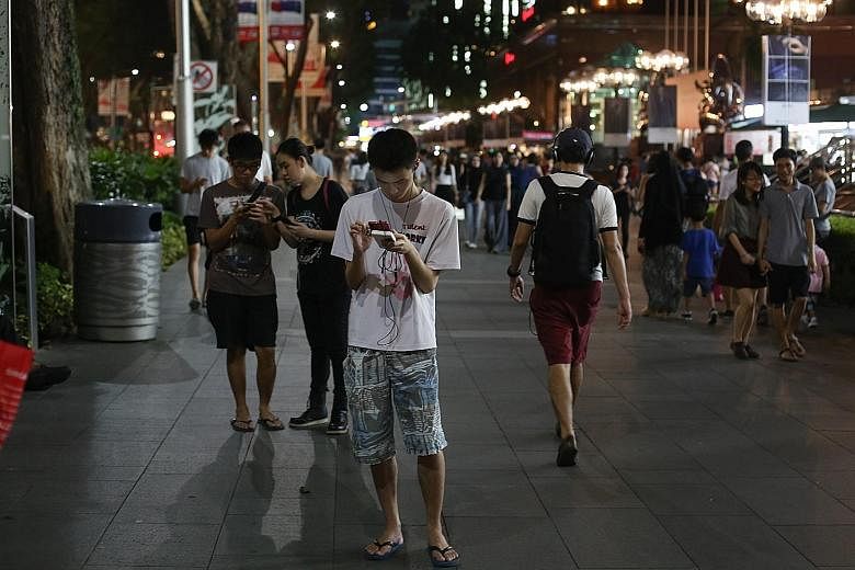 People playing Pokemon Go in Orchard Road. The smartphone app, which was launched in Singapore earlier this month, was cited in Parliament yesterday as an example of new ways of consuming content.