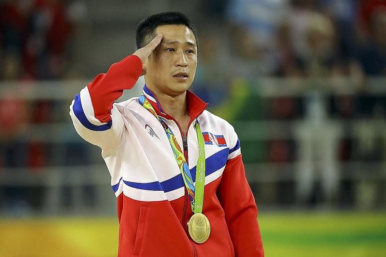 North Korea's Ri Se Gwang salutes as his country's national anthem is played during the medal ceremony. The 31-year-old crushed his vault rivals with the hardest combination of two jumps to add Olympic gold to his two world titles in 2014 and 2015.