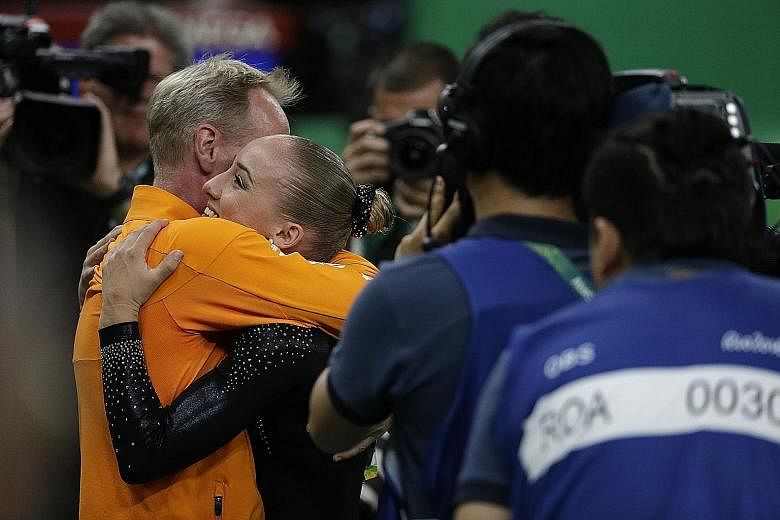 Above: Sanne Wevers of the Netherlands hugging her coach and father Vincent after receiving her gold-winning score in the balance beam final.
