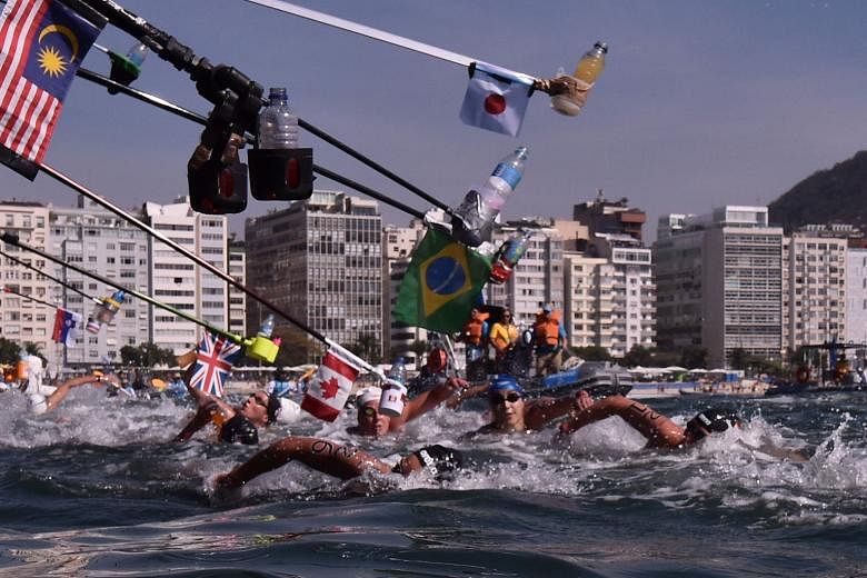 Swimmers racing past the feeding sticks in the waters off Fort Copacabana during the 10km open-water marathon. 
