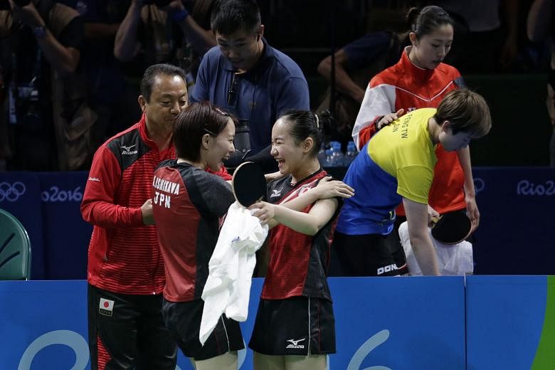 Singapore's Yu Mengyu consoling Feng Tianwei (right), while Kasumi Ishikawa (left) and Mima Ito celebrate the latter's victory over Feng, which gave Japan the winning point in their 3-1 victory over Singapore, and the team bronze. 