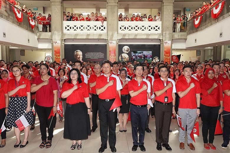 Mr Chan (centre) and People's Association chief executive director Ang Hak Seng (next to Mr Chan) reciting the pledge with some 500 PA staff during a National Day observance ceremony yesterday. The minister said terrorism is not the only threat to un