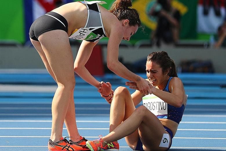 Nikki Hamblin of New Zealand (left) stops running to offer encouragement to injured Abbey D'Agostino of the United States, after the duo had accidentally collided during an earlier part of their women's 5,000m race.