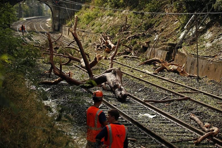 Railroad workers trying to clear the tracks near Saint-Aunes in the south of France on Wednesday. A regional train carrying 250 passengers hit a fallen tree on the tracks, between the cities of Nimes and Montpellier. At least eight people were severe