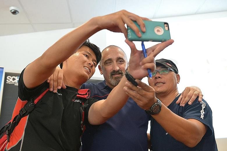 Departing national swimming coach Sergio Lopez poses for photos with participants of a discussion group on the Rio Olympics at the Sports Hub Library yesterday. The Spaniard believes that attitudes are changing among Singaporeans seeking success in s