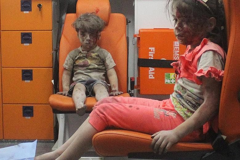 Omran sitting in an ambulance with his sister on Wednesday after they were rescued following an air strike in a rebel-held neighbourhood in Aleppo. The boy's condition and dazed expression led the US State Department to call him "the real face" of th