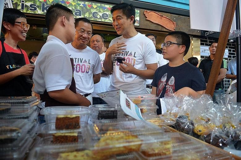 Minister for Social and Family Development Tan Chuan-Jin speaking to Shawn Tan (second from left), who is on a work attachment with Flour Power, a bakery that trains people with special needs. With them are Ms Lena Ng, Flour Power's head, NTUC FairPr