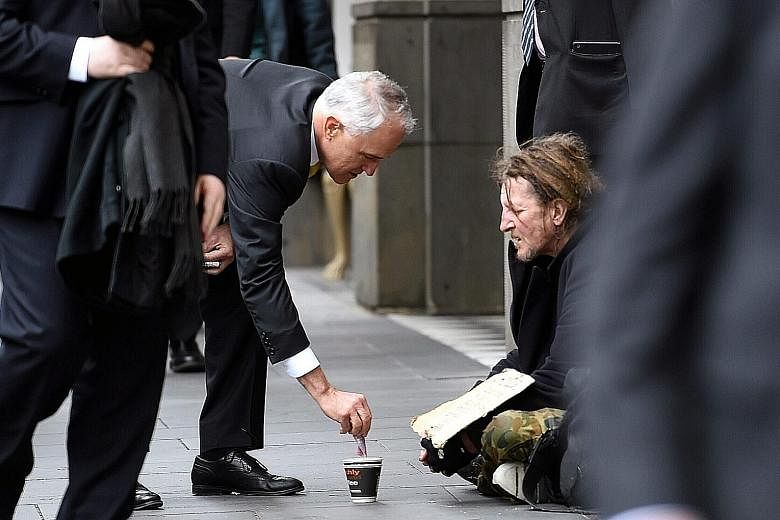 Mr Turnbull's act of depositing a $5 note into the cup of a homeless man has led to criticism from social media users and in the news media.