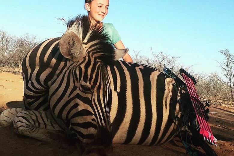 Aryanna's photos of her posing with a giraffe and zebra that she killed during a hunting trip in South Africa have ignited a firestorm on social media, with one commenter hoping that she will be killed by animals. With her and the dead giraffe is Mr 
