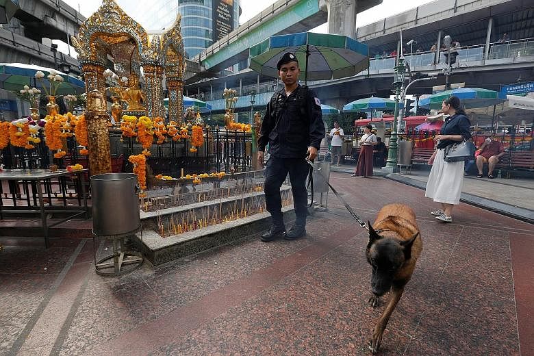 A policeman inspecting the area around the Erawan Shrine in Bangkok last Wednesday, the first anniversary of the bombing of the shrine. Even as two suspects stand trial for the assault, more than a dozen others remain at large and a convincing motive