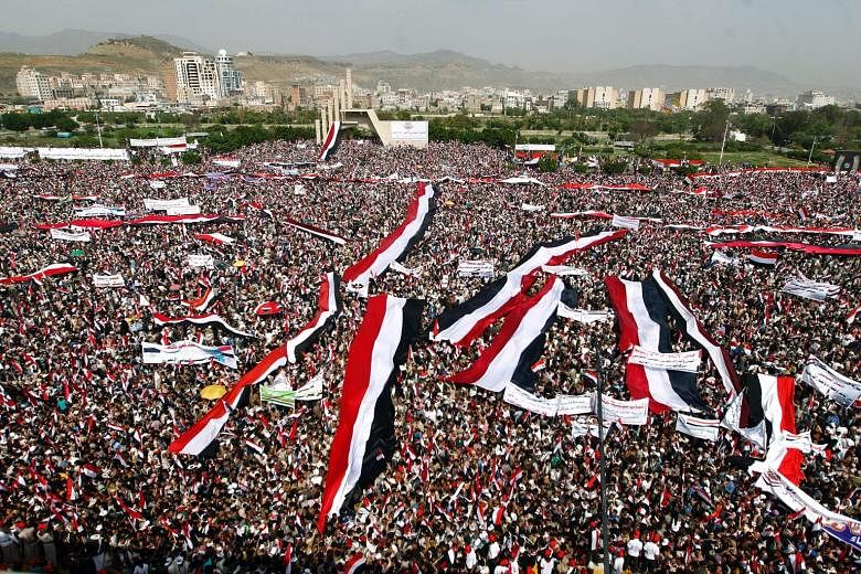 Houthi demonstrators waving Yemeni flags and chanting slogans in Sanaa's Sabeen Square on Saturday. The demonstration - one of the biggest in Yemen since the civil war broke out last year - took place as a Saudi-led coalition backing exiled President