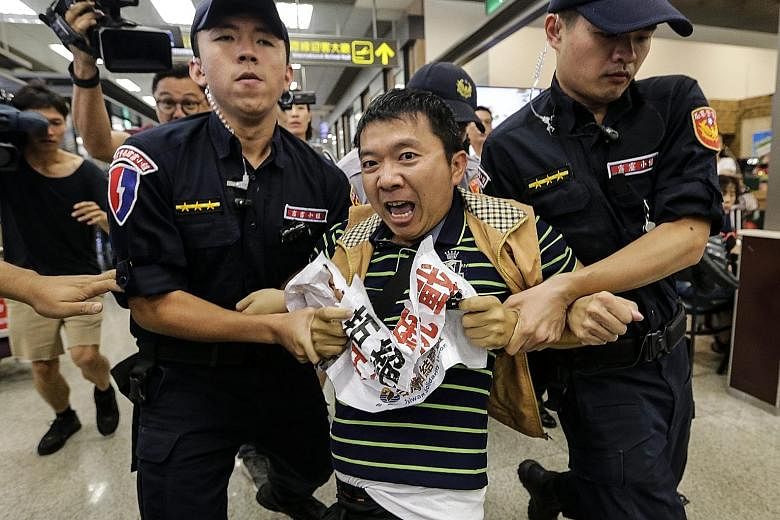 A member of the pro-independence Taiwan Solidarity Union shouting anti-China slogans while scuffling with the police at Songshan Airport in protest against the arrival of top Shanghai official Sha Hailin.