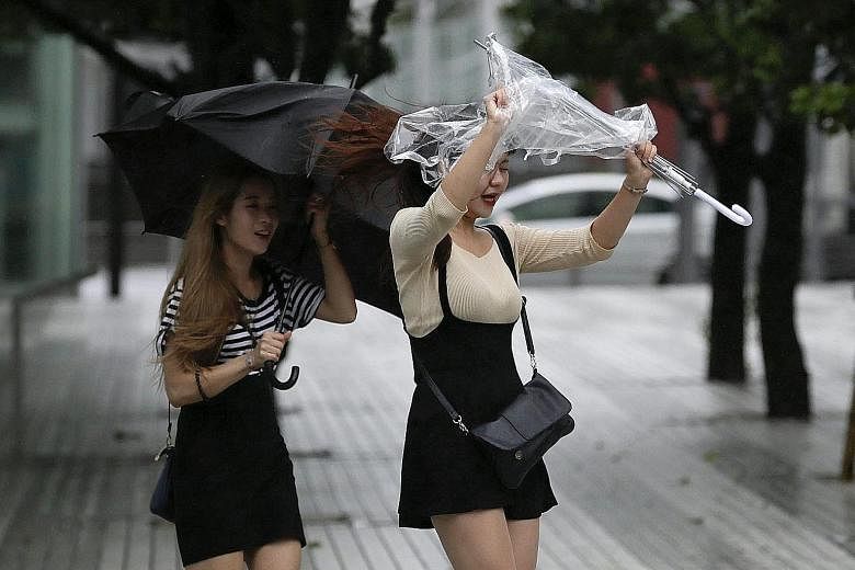 Pedestrians in Tokyo struggling against strong winds and rain when Typhoon Mindulle struck near the capital.