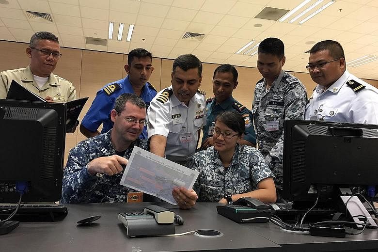 Seacat participants at the Multinational Operations and Exercises Centre at the Changi Command and Control Centre in Changi Naval Base. (Back row, from left) Lieutenant-Commander Alan Sonon of Philippines Navy; Lieutenant-Commander Nazrul Shaharin Os