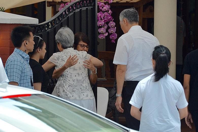 Above: Mrs Lee Hsien Loong exchanging a hug with Mr Nathan's daughter Juthika as she and PM Lee arrived at the former president's home in Ceylon Road yesterday. Below: PM Lee leaving after paying his respects. Mrs Nathan did not step out into the gla
