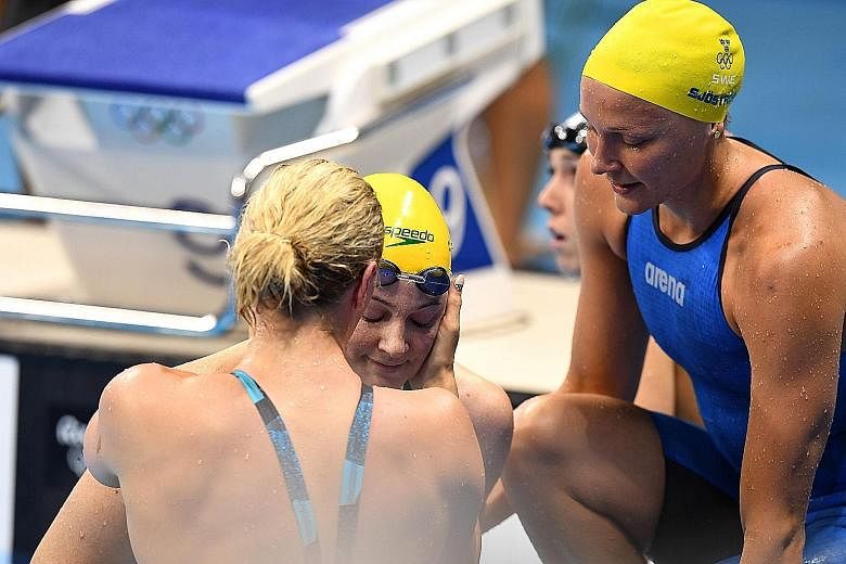 Cate Campbell of Australia (centre) is consoled by her rivals after the women's 100m freestyle final in Rio on Aug 11.