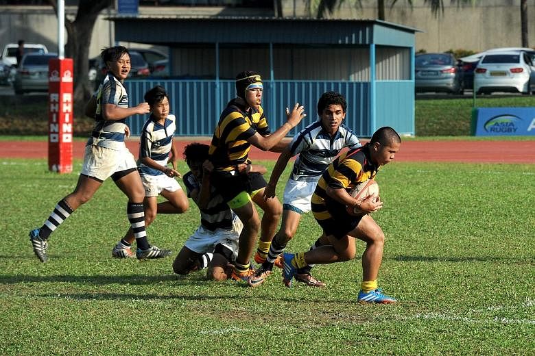 ACS(I) flanker Timothy Tan carrying the ball during the C Division final at Yio Chu Kang stadium. He scored two tries against St. Andrew's Secondary School in a rematch of last year's final.