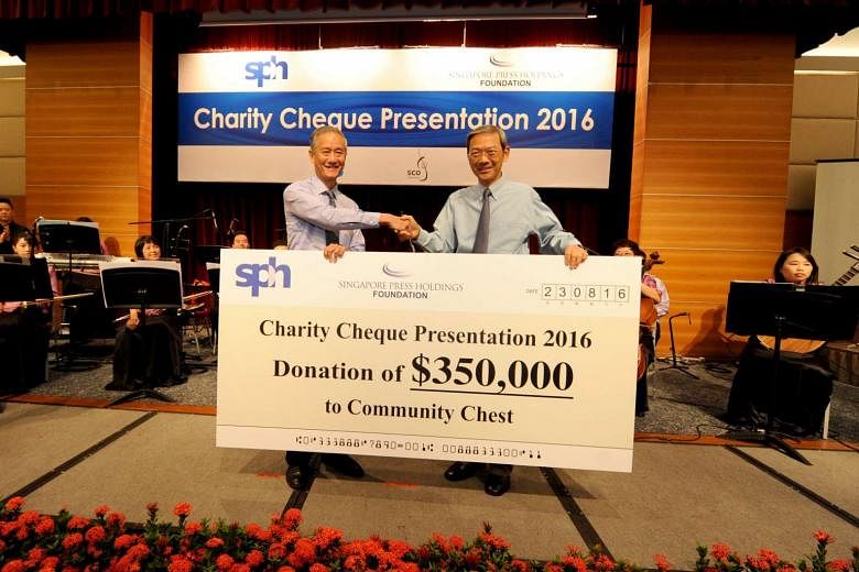 Dr Lee Boon Yang (right), chairman of SPH and SPH Foundation, presenting the cheque to Community Chest vice-chairman Eric Ang yesterday at the SPH News Centre Auditorium. 