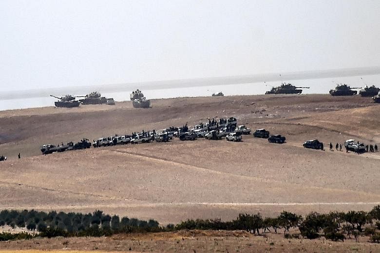 Turkish tanks and Syrian rebel fighter trucks assemble 2km west of the Turkish-Syrian border before launching their cross-border offensive on the Syrian town of Jarabulus, an ISIS stronghold.