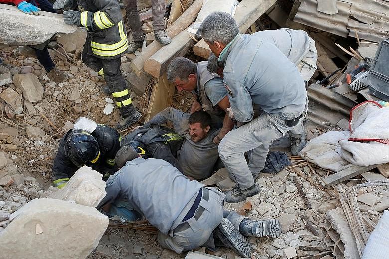 A survivor being rescued from the ruins in Amatrice, a hilltop beauty spot, following an earthquake in central Italy yesterday.