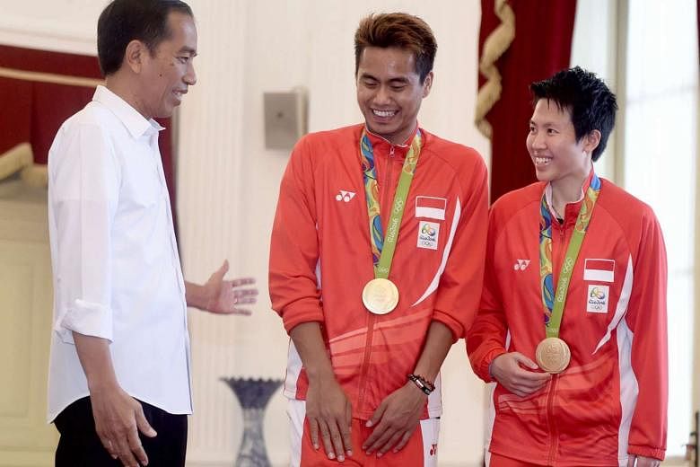 Above: Indonesian President Joko Widodo (left) congratulates gold medallists Liliyana and Tontowi at his office in Jakarta. 
