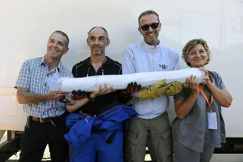 Researchers (from left) Carlo Barbante, Patrick Ginot, Jerome Chappellaz and Anne-Catherine Ohlmannpose with an ice core sample in Chamonix, eastern France, after extracting two of them - each over 120m long - from a Mont Blanc glacier. The two ice c