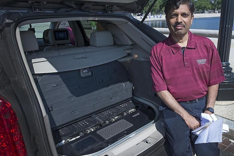 Carnegie Mellon University don Raj Rajkumar, shown here in 2014 with the main control centre of a self-driven car. He is more convinced than ever that introducing safe-driving features - lane-departure warnings, cameras and sensors - gradually is the