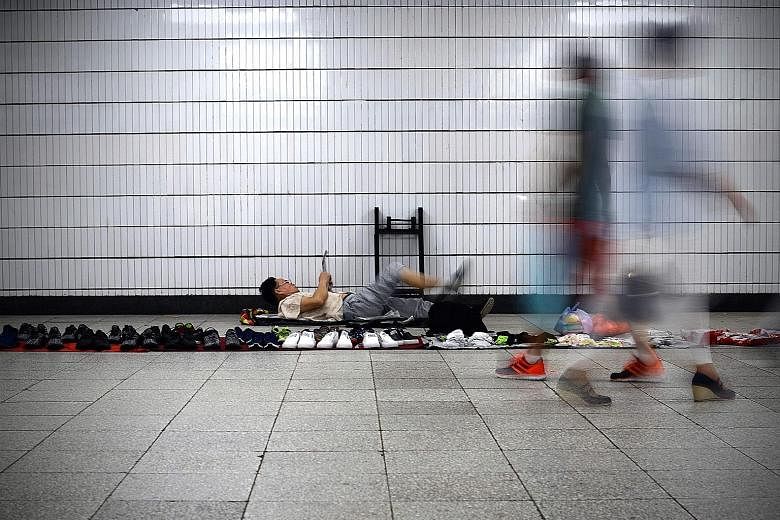A shoe vendor waiting for customers in a Beijing underpass. The P2P lending sector has been a source of funds for individuals and small businesses overlooked by China's traditional financial services institutions, which prefer big borrowers with bett