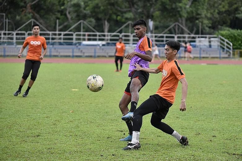 Hougang United striker Iqbal Hussain (in purple vest) challenges Haidil Sufian for the ball during training at Hougang Stadium on Wednesday.