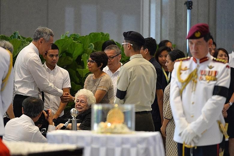 Above: PM Lee greeting Ms Juthika, daughter of Mr Nathan, at Parliament House yesterday. Also present was Mr Nathan's wife, Madam Urmila Nandey (in a wheelchair). Right: Former MP Mr Chiam being assisted by his wife, former Non-Constituency MP Mrs Ch