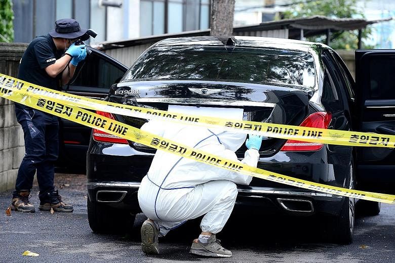 Investigators examining a car owned by Mr Lee at a police station in Yangpyeong, South Korea, yesterday. The body of the Lotte Group vice-chairman was reported to be found hanged from a tree near a hiking trail in the town. Mr Lee had been with Lotte