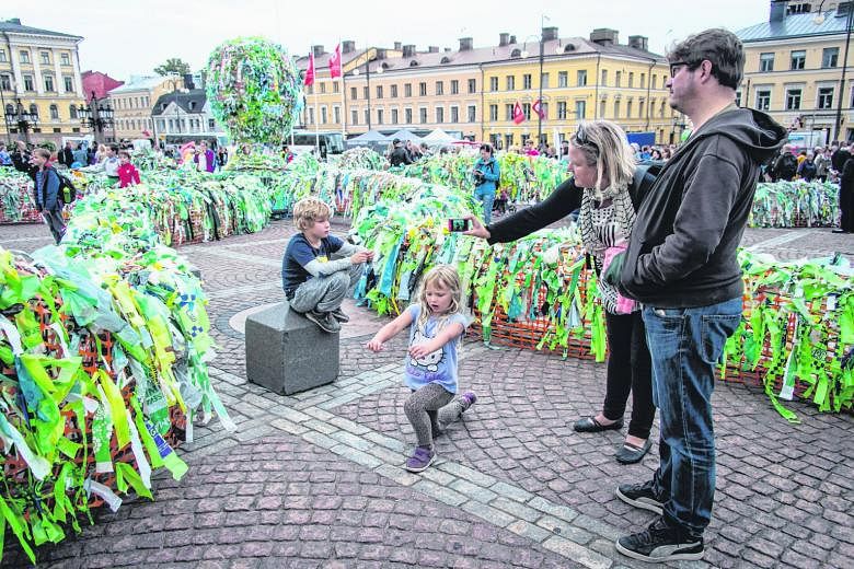 A family looking at the octopus-shaped installation Sea Lives by South Korean artist Choi Jeong Hwa on Thursday. The artwork, made of recycled plastic, was displayed during the Night Of The Arts in Senate Square in Helsinki, Finland. Recycled materia