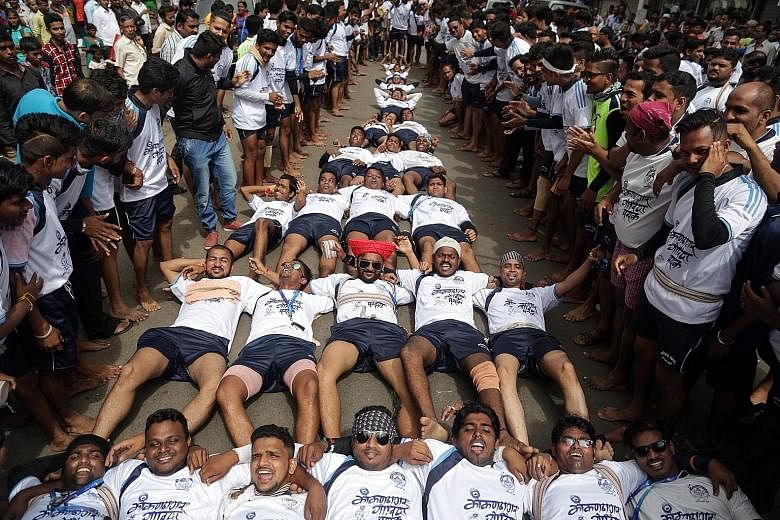 Indian devotees forming a horizontal human pyramid on the ground in Mumbai, India, to protest against a reported Supreme Court ban on youth under the age of 18 from taking part in forming human pyramids to celebrate Dahi Handi during the Janmashtami 