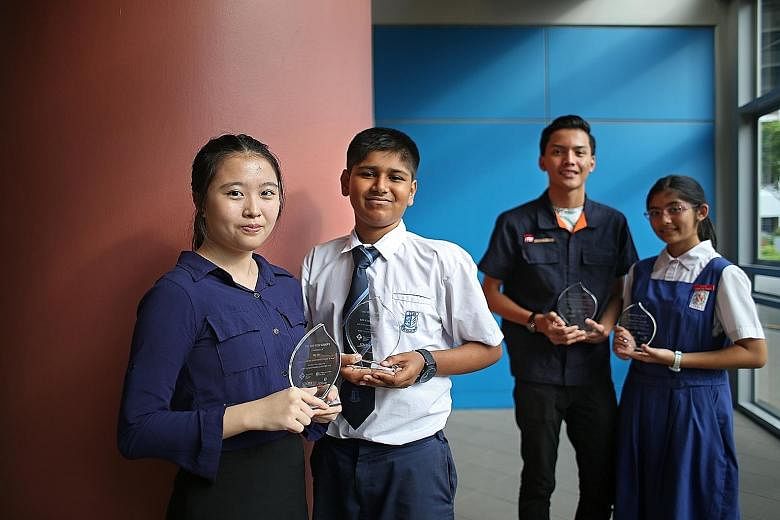 From left: Students Ng Hui, 17; Abdur Rahman Galib, 13; Muhammad Izzul Isam Jamil, 17, and Faustina Anne Francisco, 13, received awards from the four self-help groups for doing well at different levels of national examinations last year.