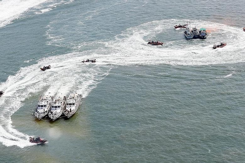 High-speed boats from the Korea Coast Guard and navy surround vessels simulating foreign boats fishing illegally in South Korean waters during an exercise in the West Sea last Friday. A vast number of Chinese boats allegedly cross into South Korean w